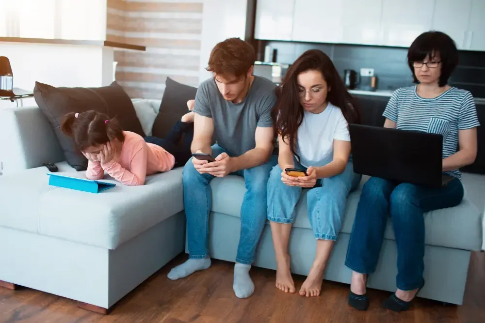 Parents and kids distracted by devices instead of spending quality time.webp